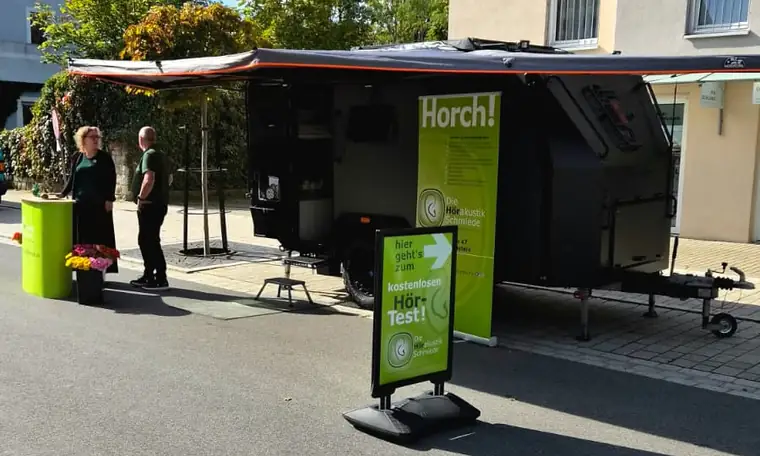 Das Hörmobil der HörakustikSchmiede mit Aufsteller für den kostenlosen Hörtest