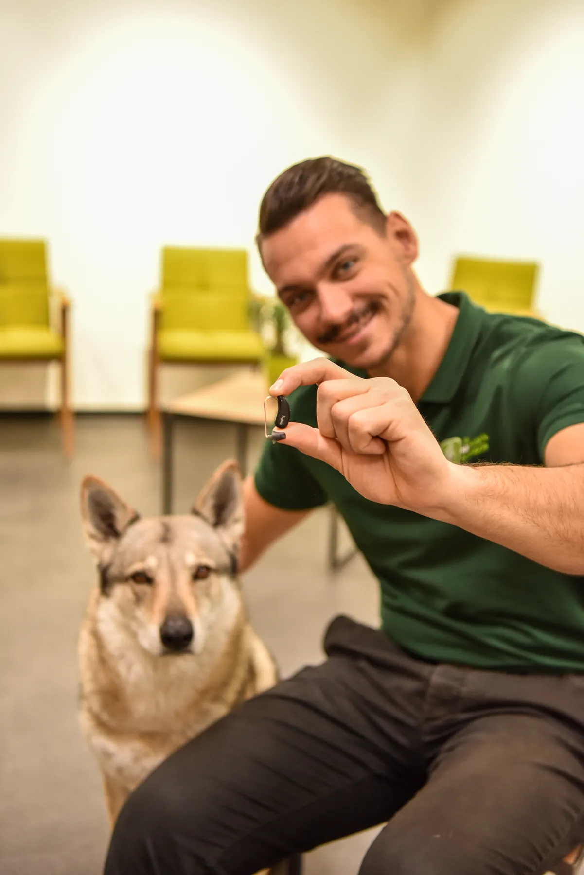 Maximilian Wünschig mit einem Hörgerät in der Hand
